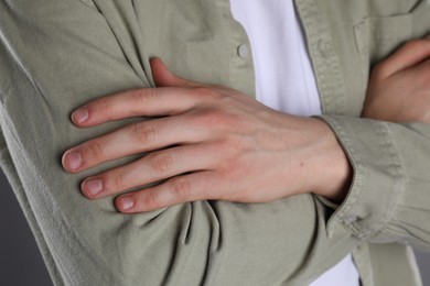 Photo of Man with space for tattoo on his hands against grey background, closeup