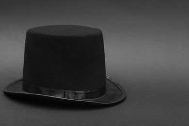 Photo of One magician top hat on dark grey background, space for text