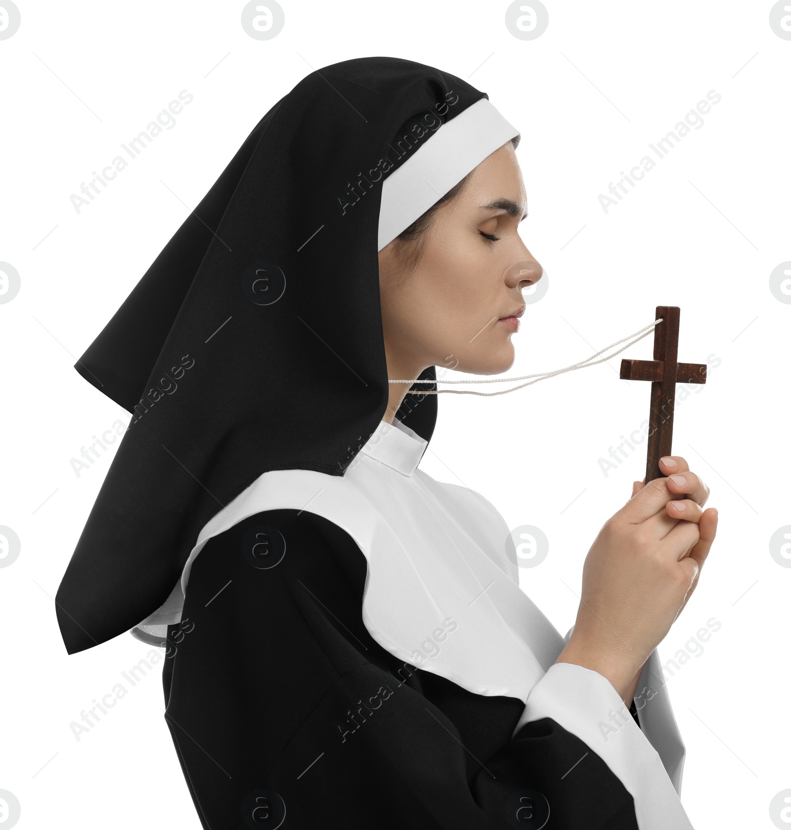 Photo of Nun holding wooden cross and praying to God on white background