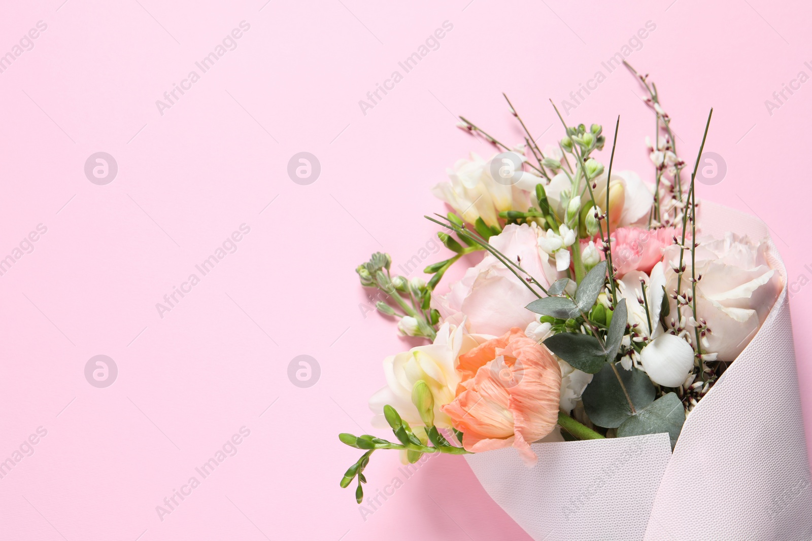 Photo of Bouquet of beautiful flowers on pink background, top view. Space for text