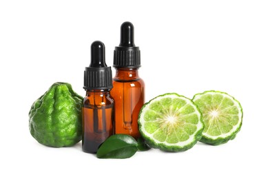 Photo of Bottles of essential oil, fresh bergamot fruits and leaves on white background