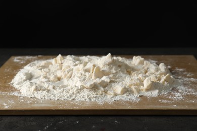 Photo of Making shortcrust pastry. Flour, butter and board on grey table