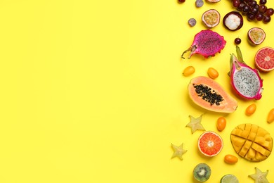 Many different delicious exotic fruits on yellow background, flat lay. Space for text