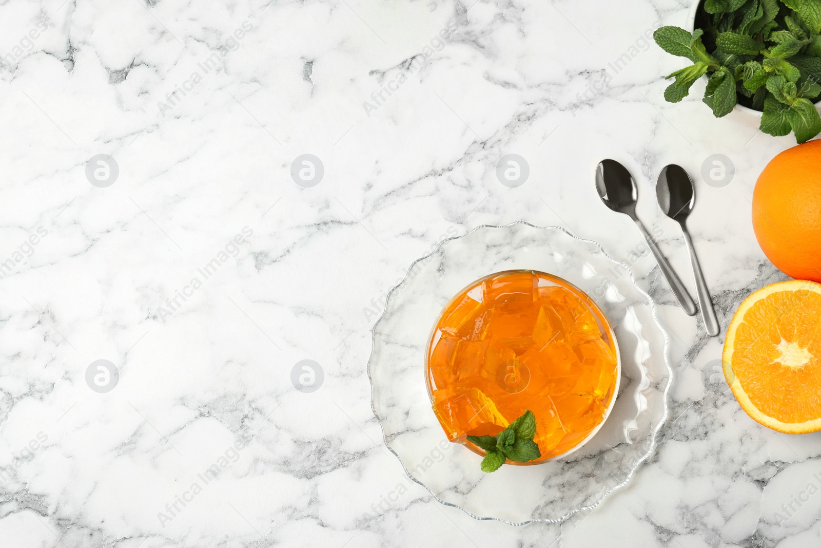 Photo of Flat lay composition with orange jelly in  bowl on marble table. Space for text