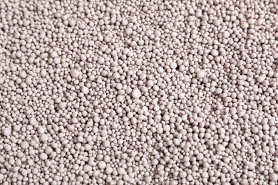 Photo of Textured chemical fertilizer for gardening as background, top view