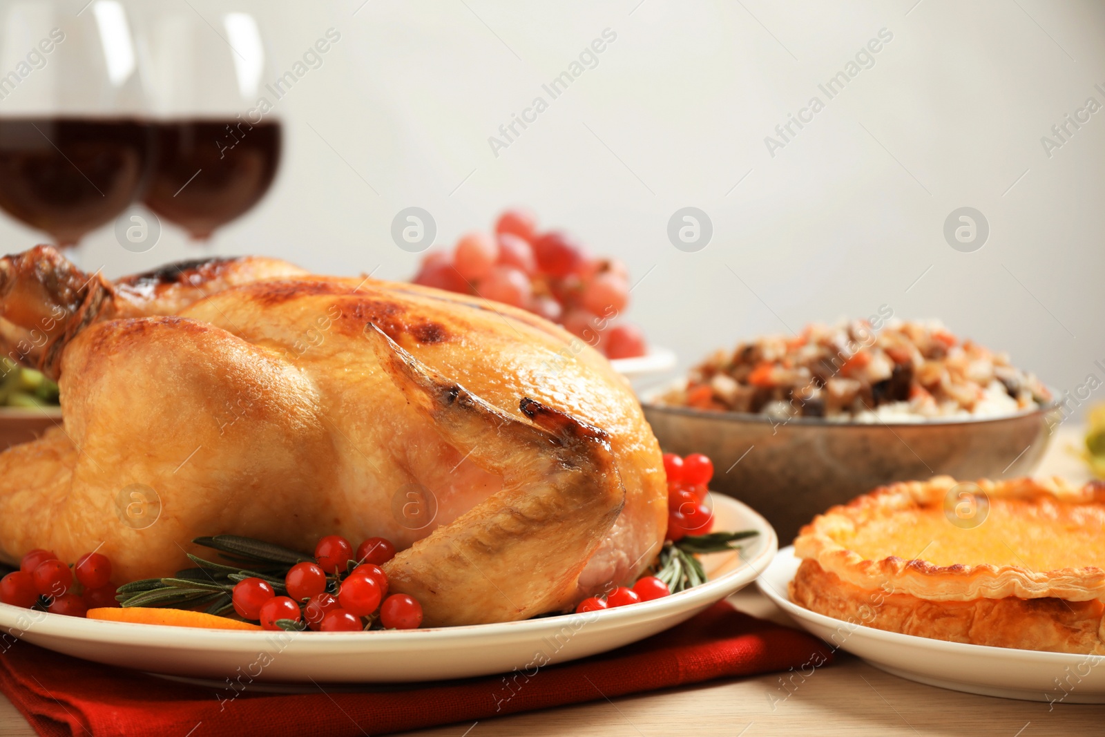 Photo of Traditional Thanksgiving day feast with delicious cooked turkey and other seasonal dishes served on table, closeup