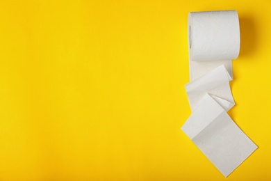 Photo of Roll of toilet paper on color background, top view. Space for text