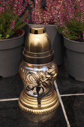 Photo of Grave lantern on black tiled surface at cemetery