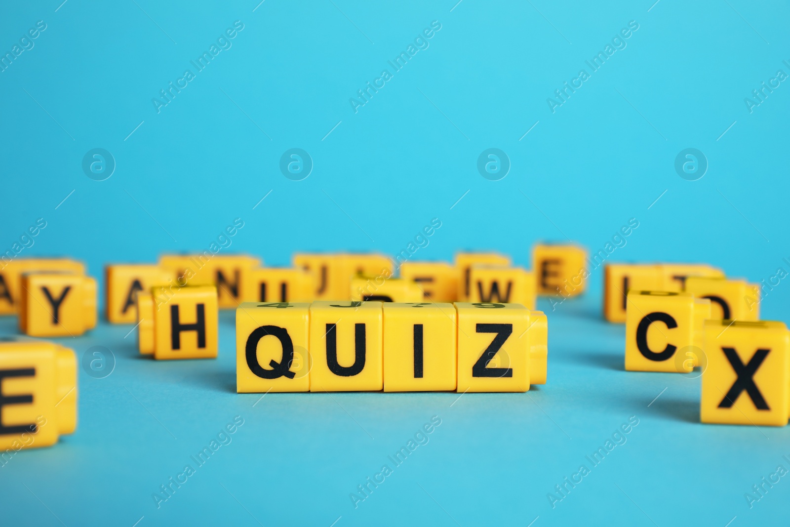 Photo of Yellow cubes with word Quiz on light blue background. Space for text