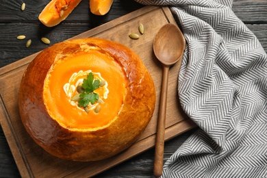 Flat lay composition with pumpkin soup served in bread on table