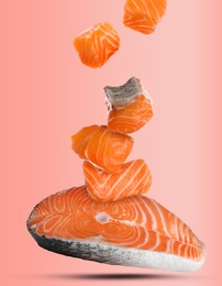 Image of Cut fresh salmon falling on pink background