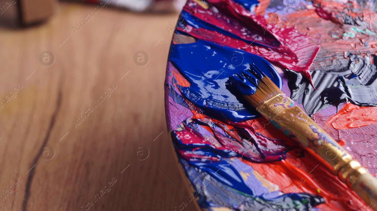 Photo of Artist's palette with mixed paints and brush, closeup