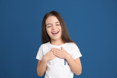 Portrait of cute little girl on blue background