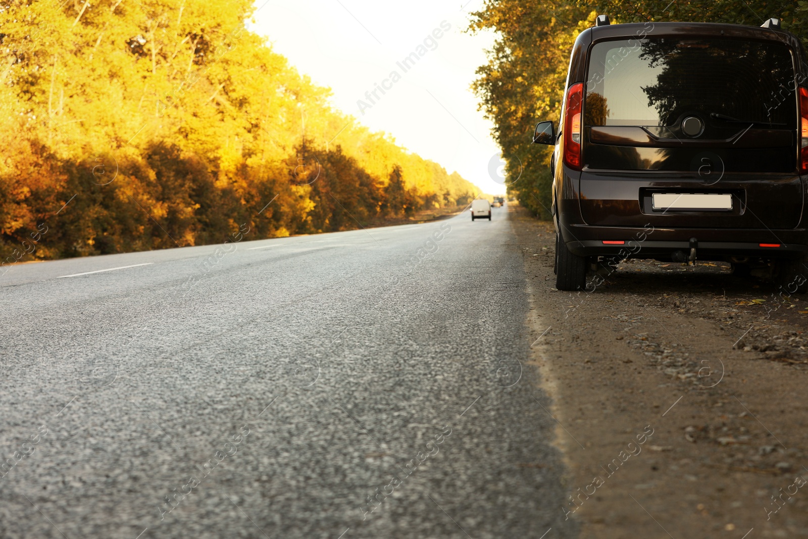 Photo of Car parked on country road. Space for text