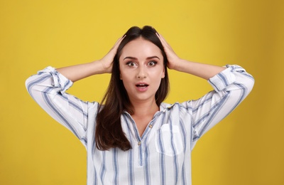 Photo of Emotional young woman in casual outfit on yellow background