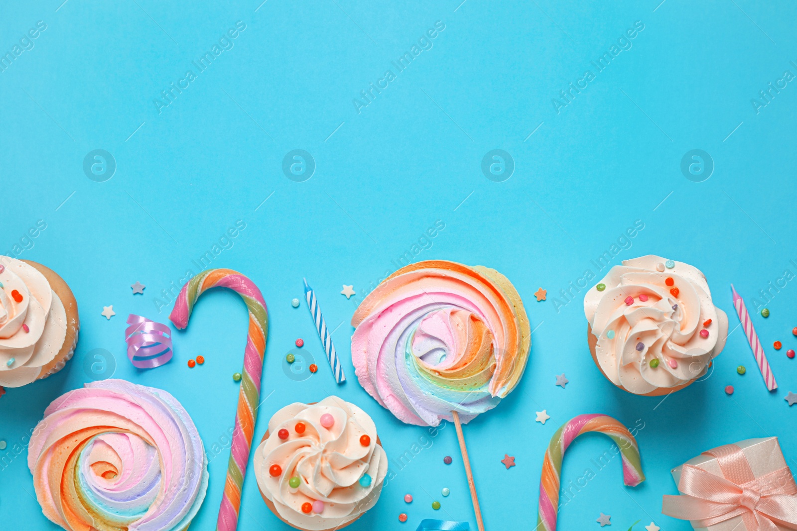 Image of Flat lay composition with cupcakes on light blue background. Space for text