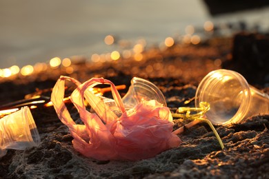 Photo of Plastic garbage at beach, closeup and space for text. Environmental pollution concept