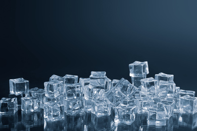 Photo of Crystal clear ice cubes on black background. Space for text