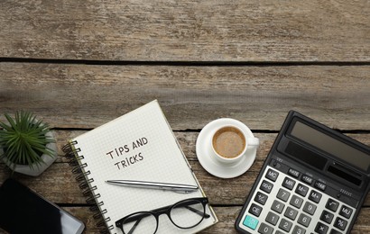 Flat lay composition with notebook on wooden table, space for text. Tips and Tricks