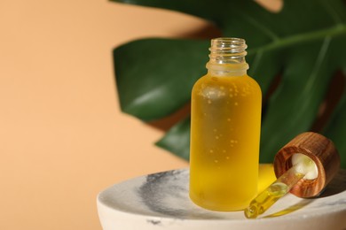 Photo of Bottle of face serum on soap dish against beige background, closeup. Space for text