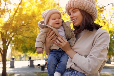Photo of Happy mother with her baby son in park on autumn day