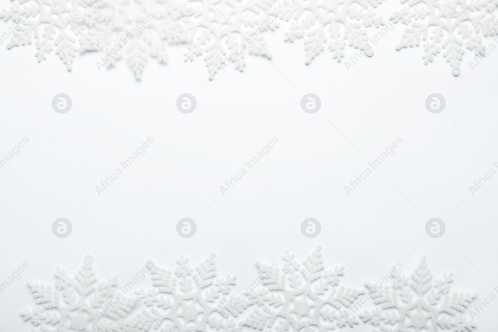 Photo of Beautiful decorative snowflakes on white background, flat lay. Space for text