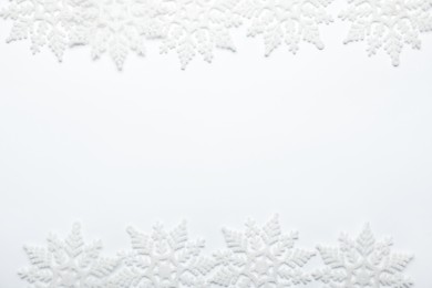 Photo of Beautiful decorative snowflakes on white background, flat lay. Space for text