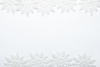 Beautiful decorative snowflakes on white background, flat lay. Space for text