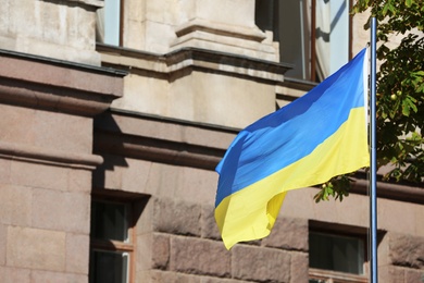 Photo of National flag of Ukraine near building on city street