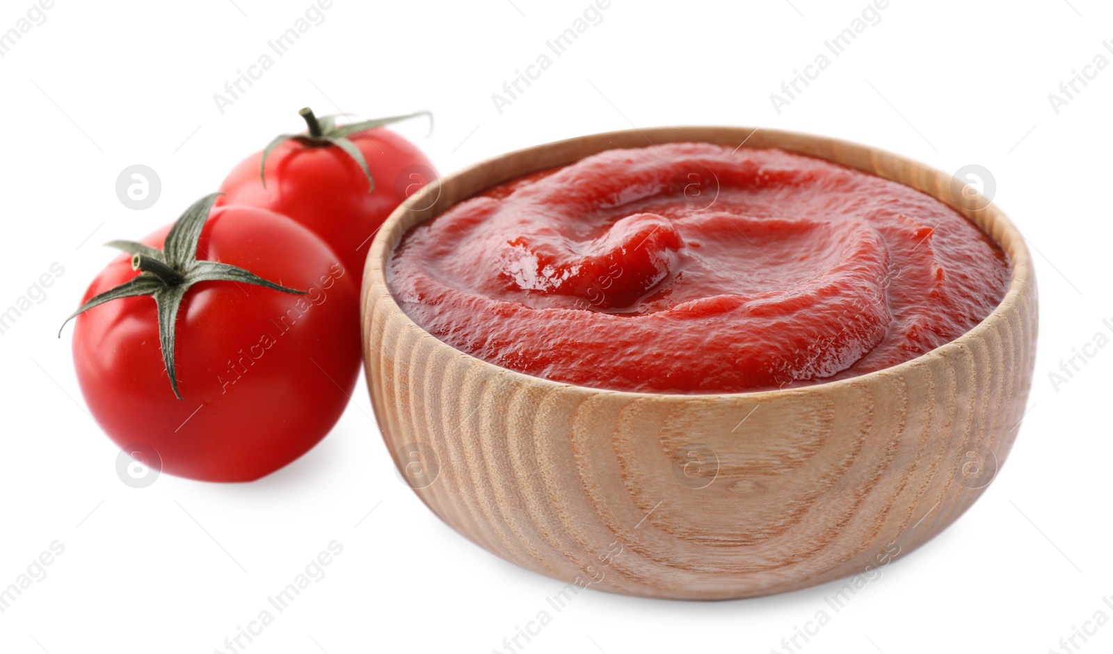 Photo of Tasty ketchup in wooden bowl and fresh tomatoes isolated on white, closeup