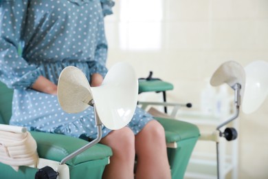 Photo of Gynecological checkup. Woman sitting on examination chair in hospital, selective focus. Space for text