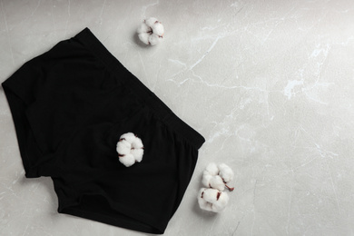 Photo of Men's underwear and cotton flowers on light grey marble background, flat lay