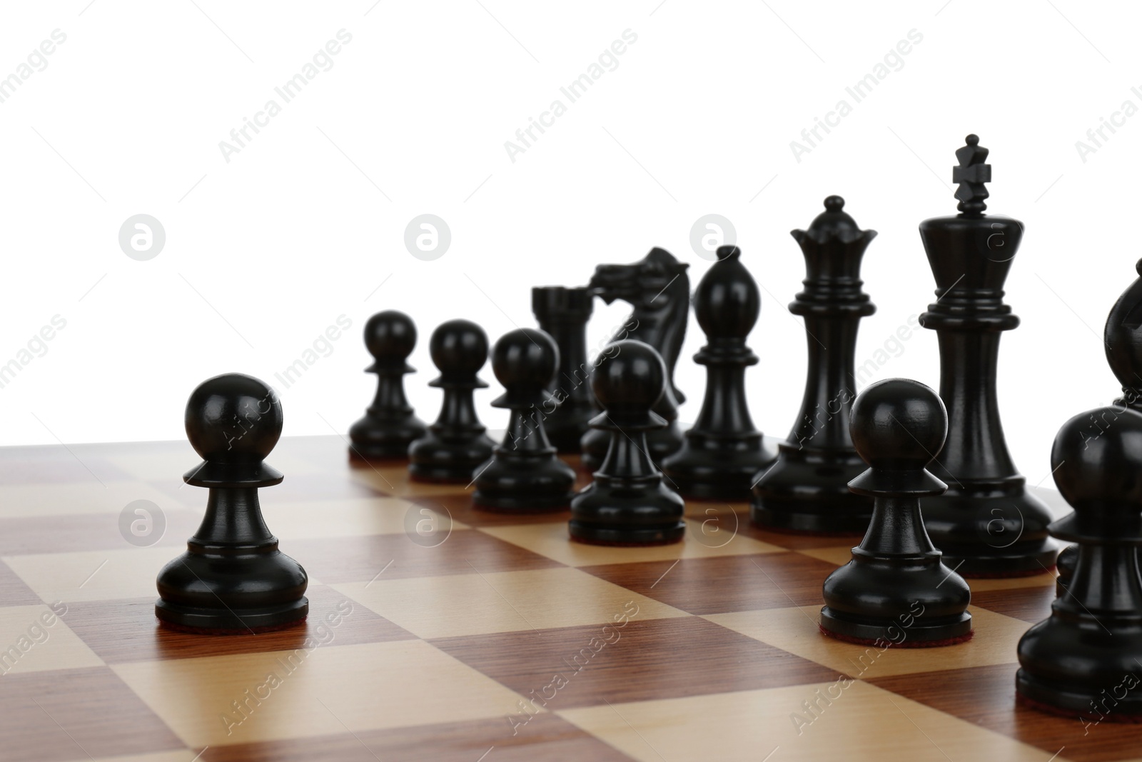 Photo of Black pawn in front of other chess pieces on wooden board against white background