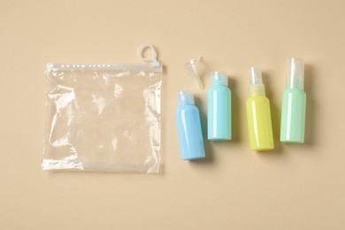 Cosmetic travel kit and plastic bag on beige background, flat lay. Bath accessories