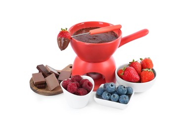 Photo of Fondue pot with melted chocolate, fresh berries and fork isolated on white