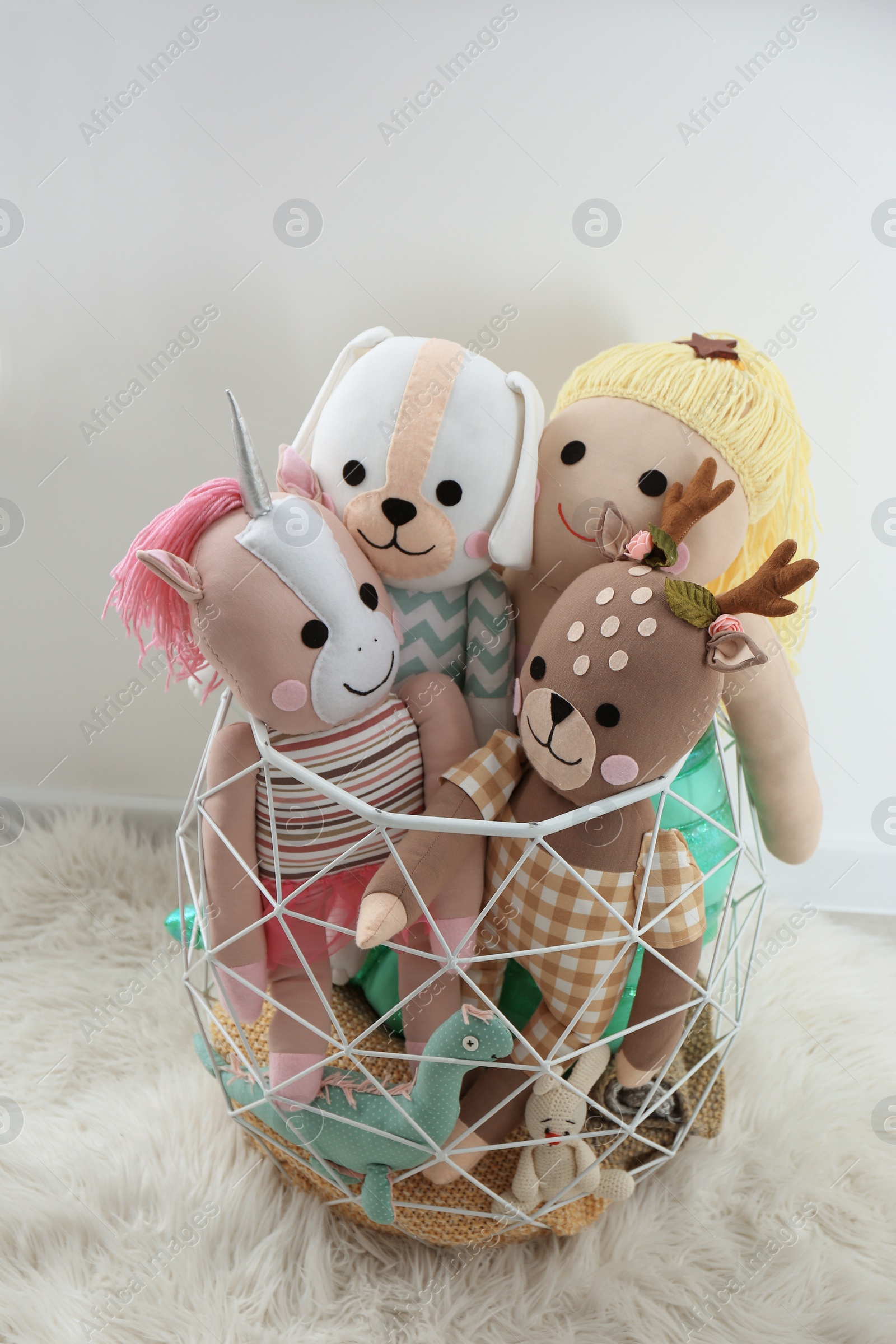 Photo of Funny toys in basket on floor. Decor for children's room interior