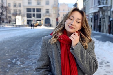 Photo of Portrait of charming woman on city street in winter. Space for text