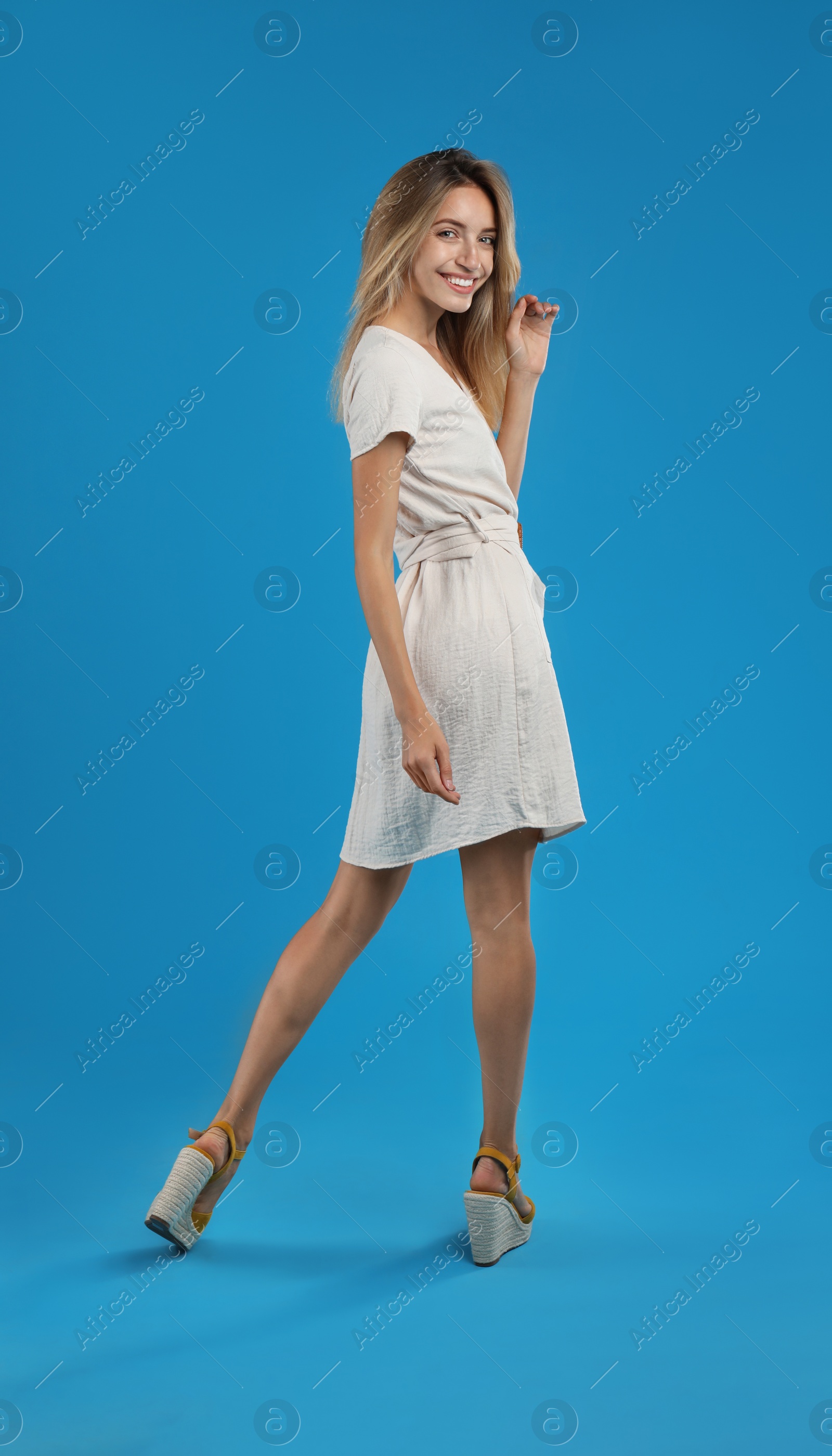 Photo of Young woman wearing stylish dress on blue background