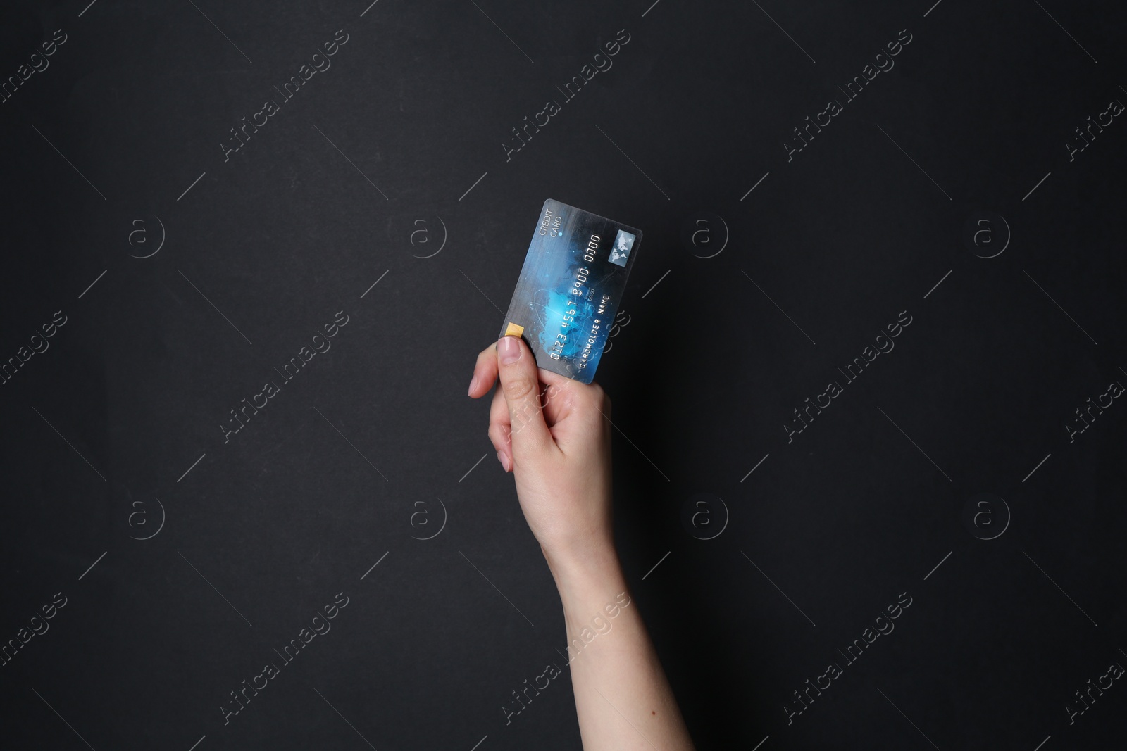 Photo of Woman holding credit card on black background, closeup