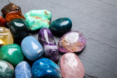 Photo of Different beautiful gemstones on grey background, closeup