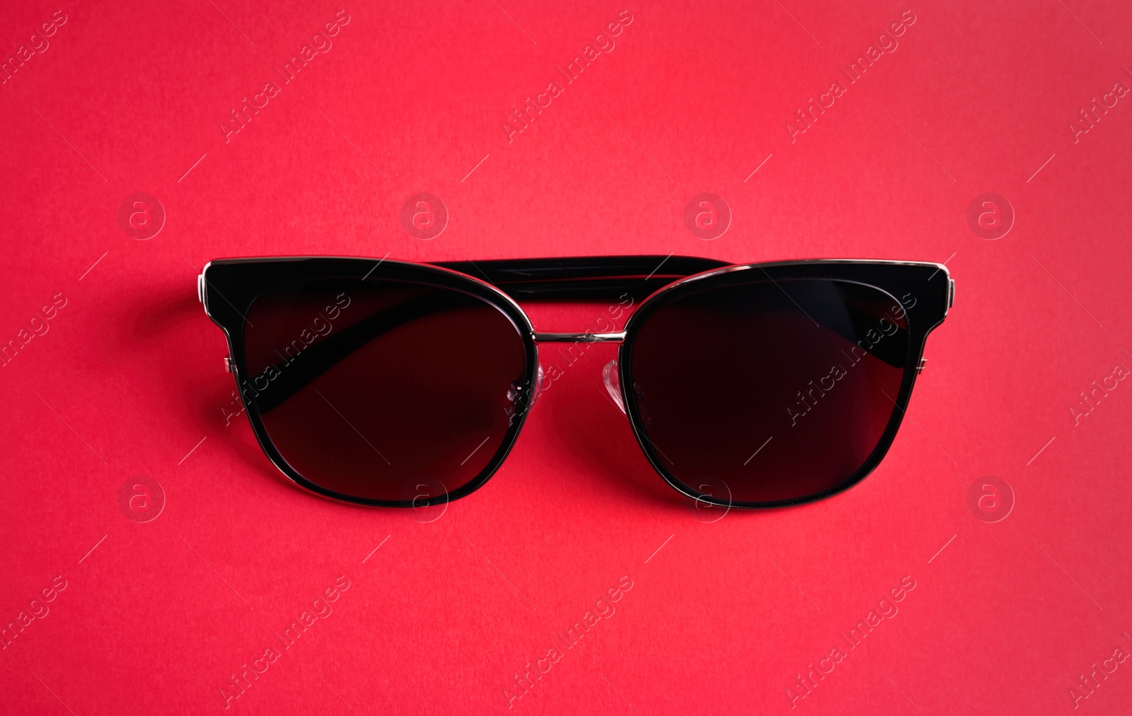 Photo of Stylish sunglasses on pink background, top view