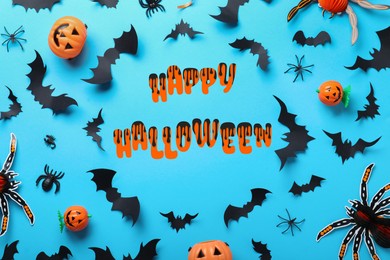 Frame made with Halloween decor elements on light blue background, flat lay