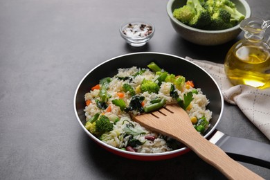 Photo of Tasty fried rice with vegetables served on black table, closeup