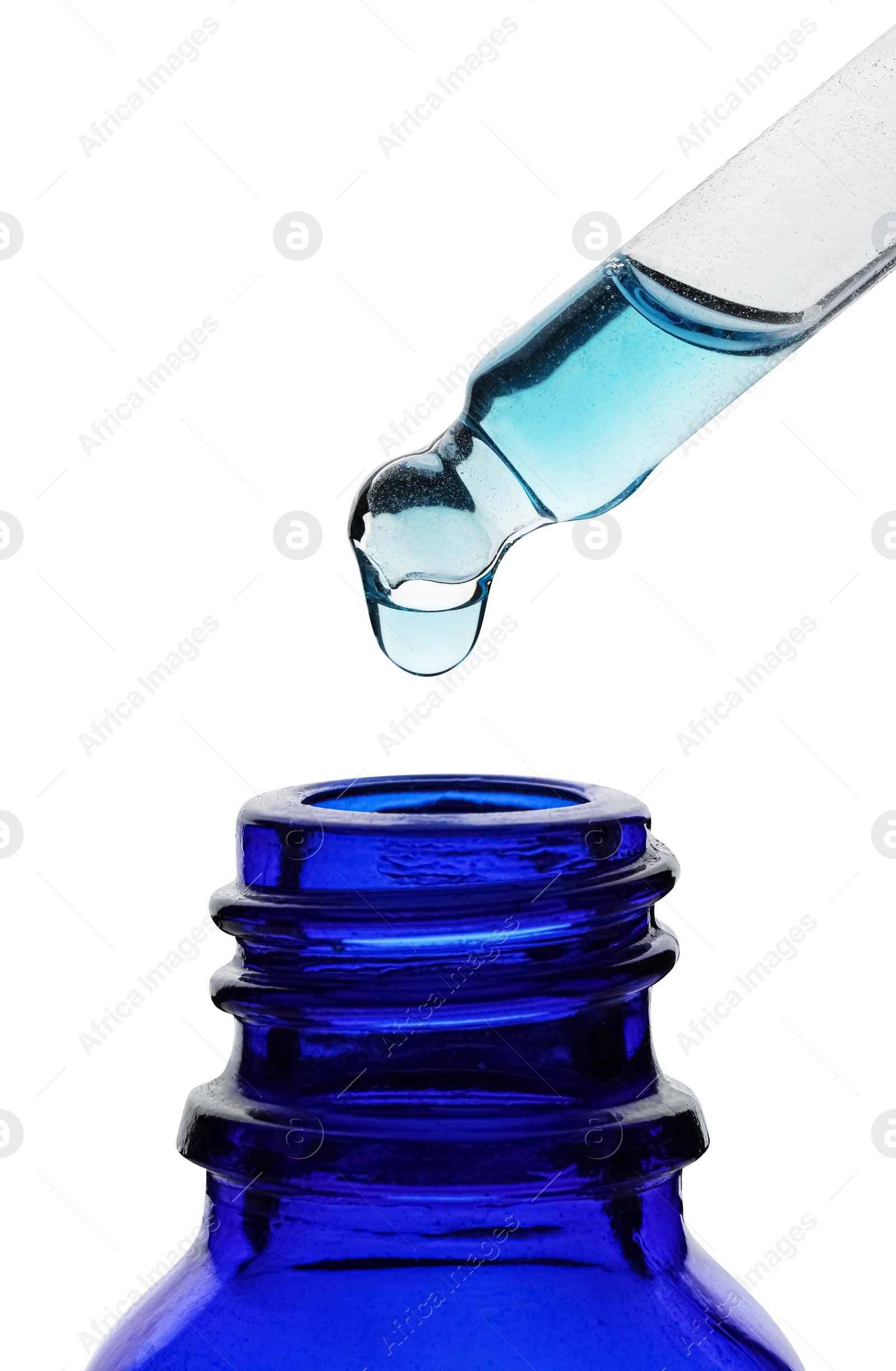 Photo of Dripping light blue facial serum from pipette into glass bottle on white background, closeup