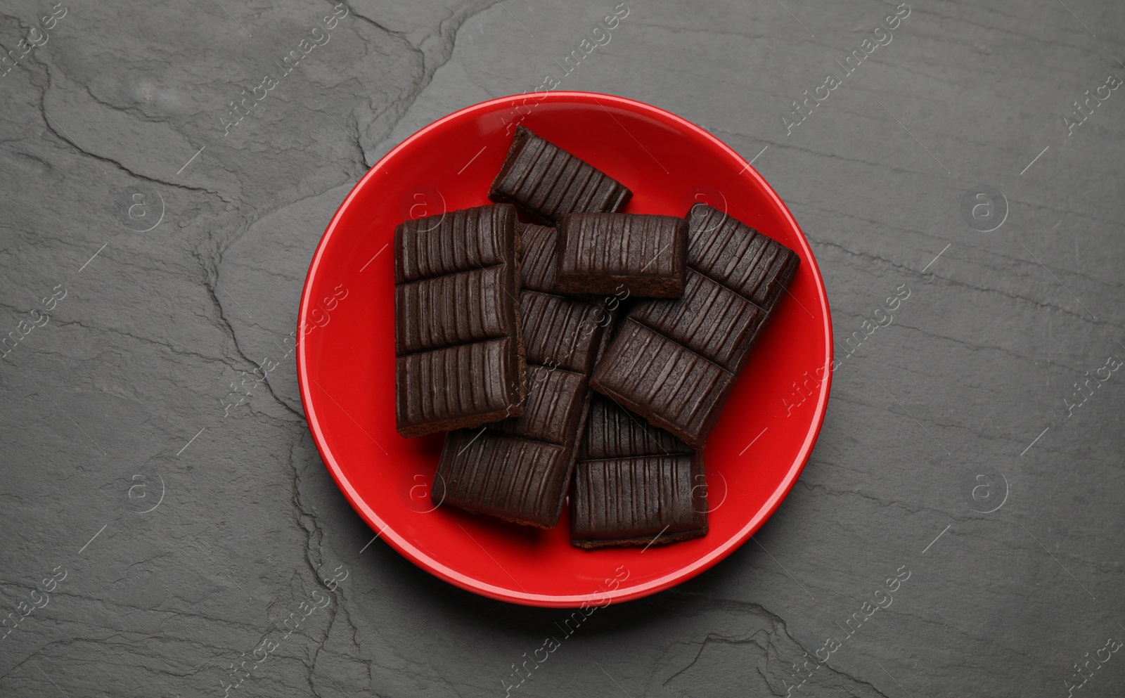 Photo of Red plate with delicious and healthy hematogen on black table, top view