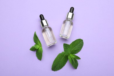 Photo of Bottles of essential oil and mint on violet background, flat lay