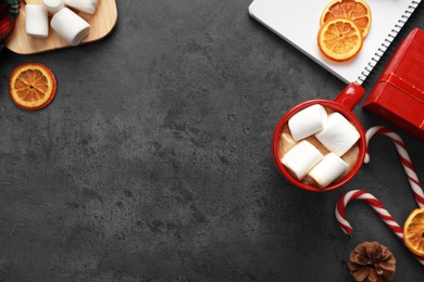 Photo of Flat lay composition with cup of tasty cocoa and sweets on dark grey table, space for text. Cozy winter