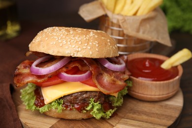 Tasty burger with bacon, vegetables and patty served with french fries and ketchup on table, closeup