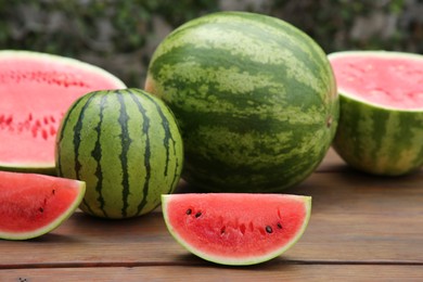 Delicious whole and cut watermelons on wooden table