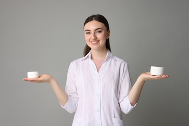 Cosmetologist with cosmetic products on grey background